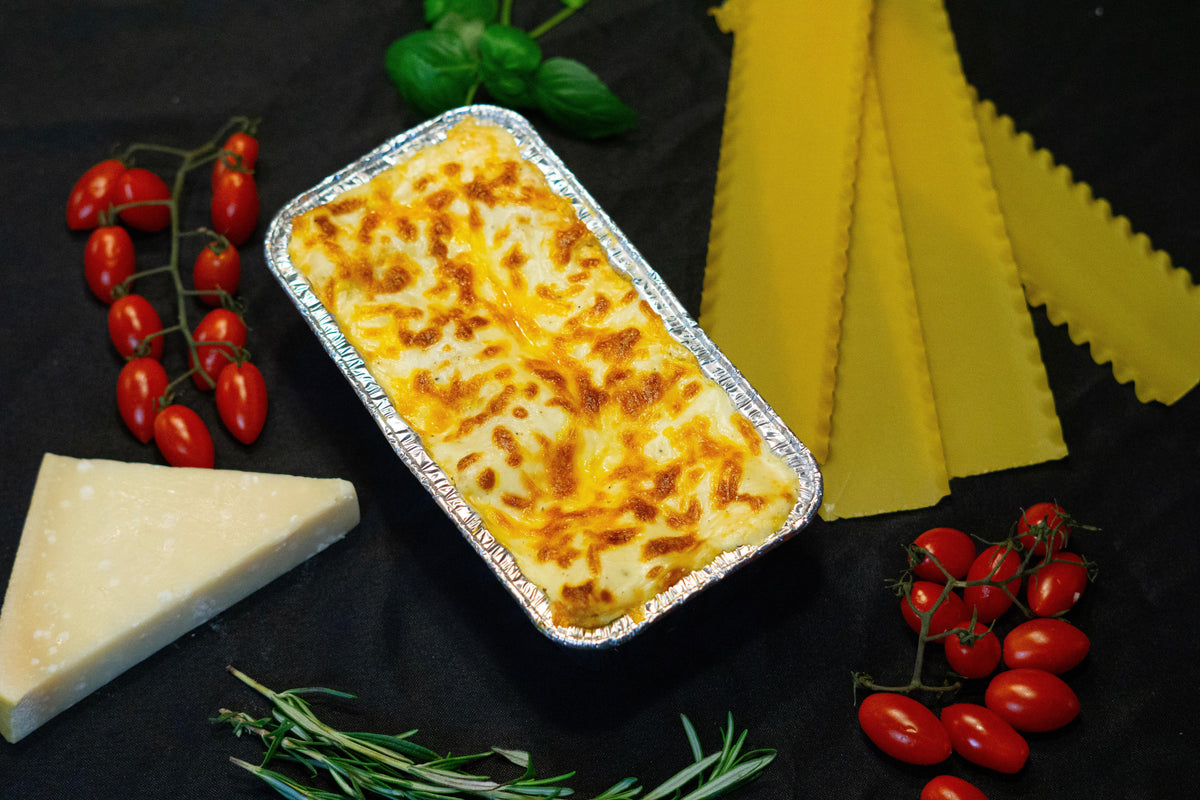 Creamy Makaroni Béchamel by WOWSHI served in a bowl with a golden-brown baked crust and fresh herbs garnish.